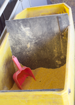 A rolling cart full of feed, with panel and scoop.